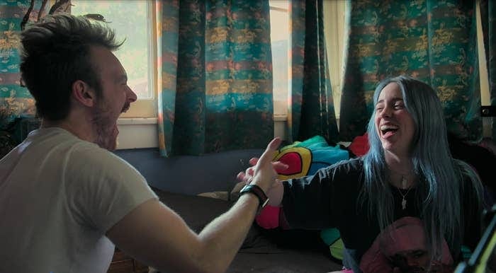 Finneas O’Connell and Billie Eilish laughing together in a bedroom studio